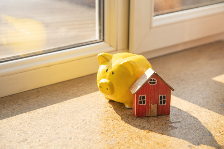 Piggy bank next to a small model house